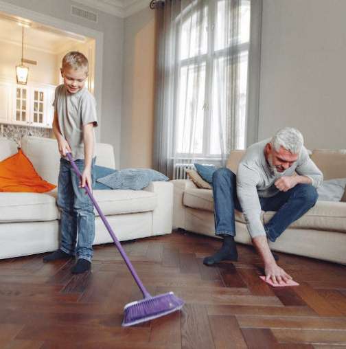 Father shows son how to clean the floor